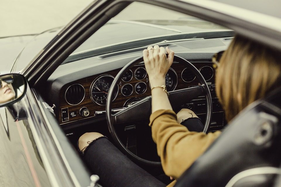 Imagem de uma mulher ao volante de um belo automóvel antigo Interatividade Corretora de Seguros